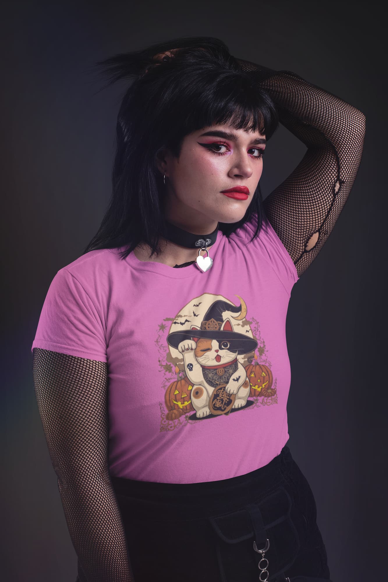 Model wearing classic women’s Witchy Neko Halloween t-shirt with artistic lucky cat design in orange, gold, and cream tones