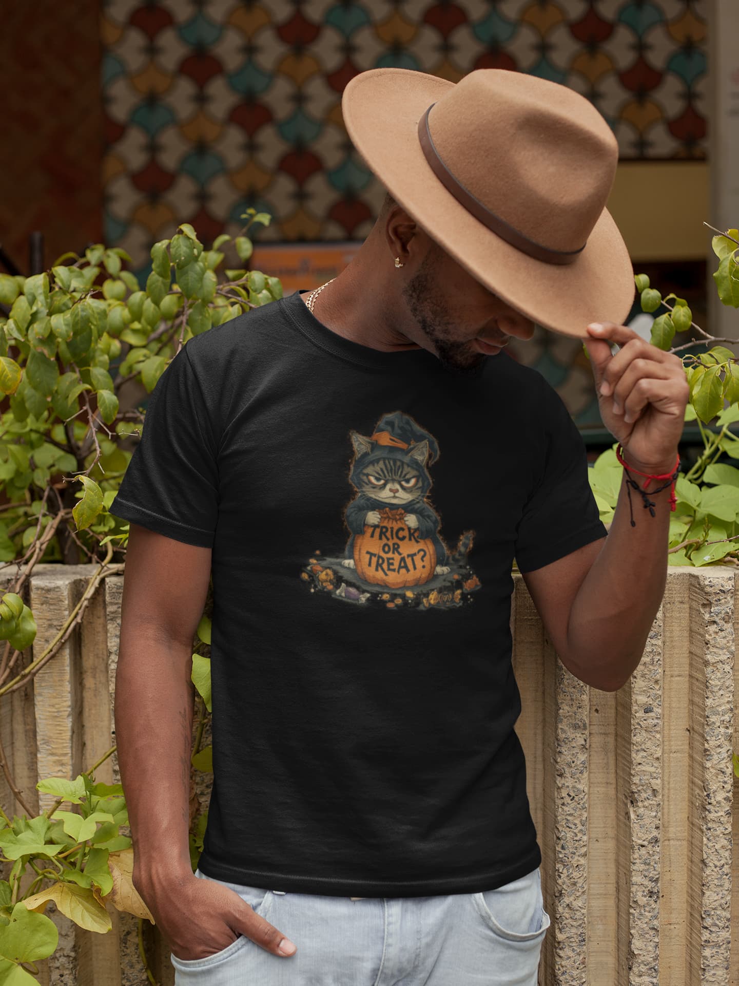 Model wearing Trick or Treat Cat unisex premium Halloween t-shirt with spooky vintage poster-style black cat design
