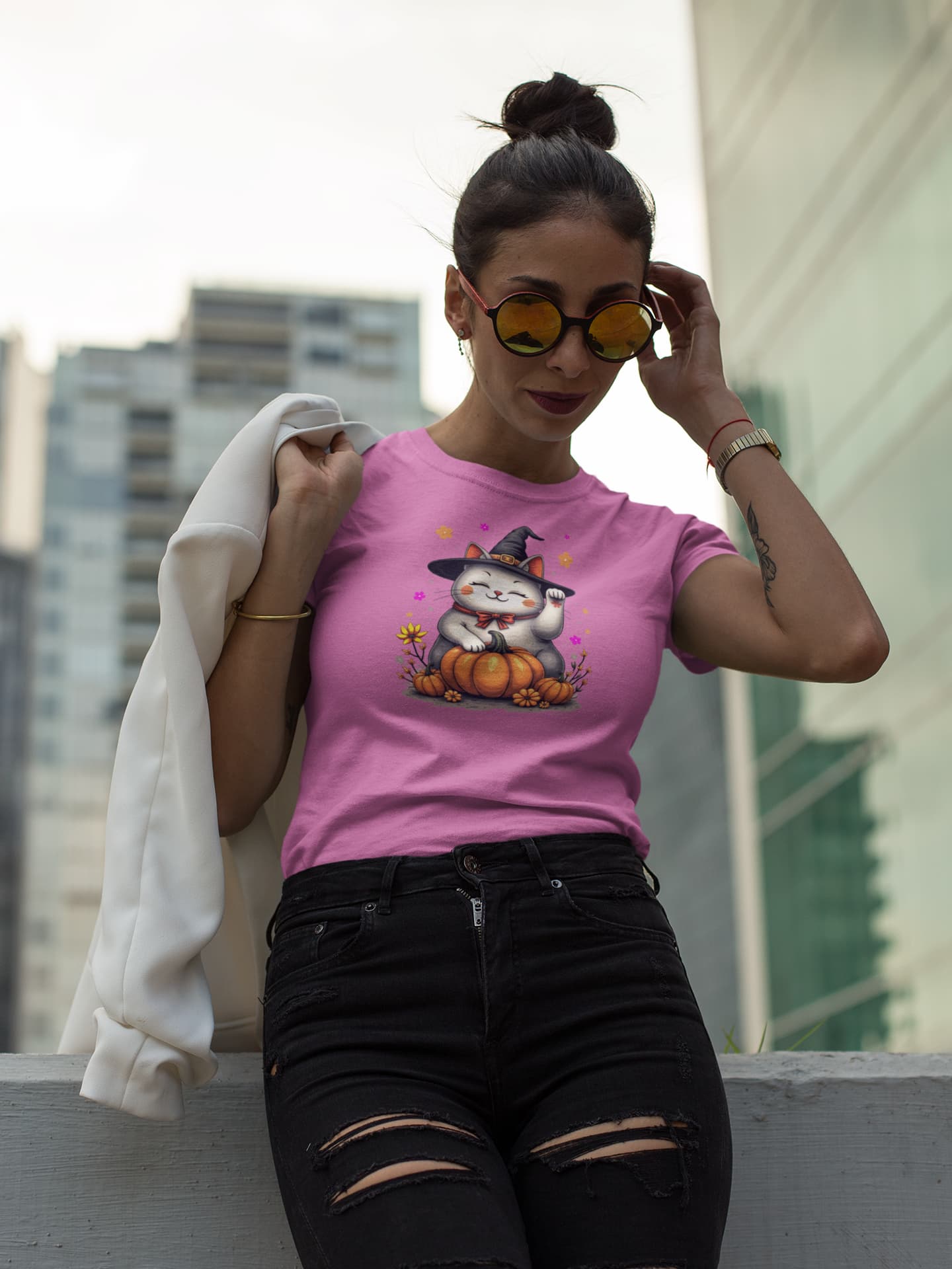 Model wearing Witch Luck Halloween cat t-shirt with lucky Maneki-neko cat in witch hat surrounded by colorful flowers, feminine and mystical design