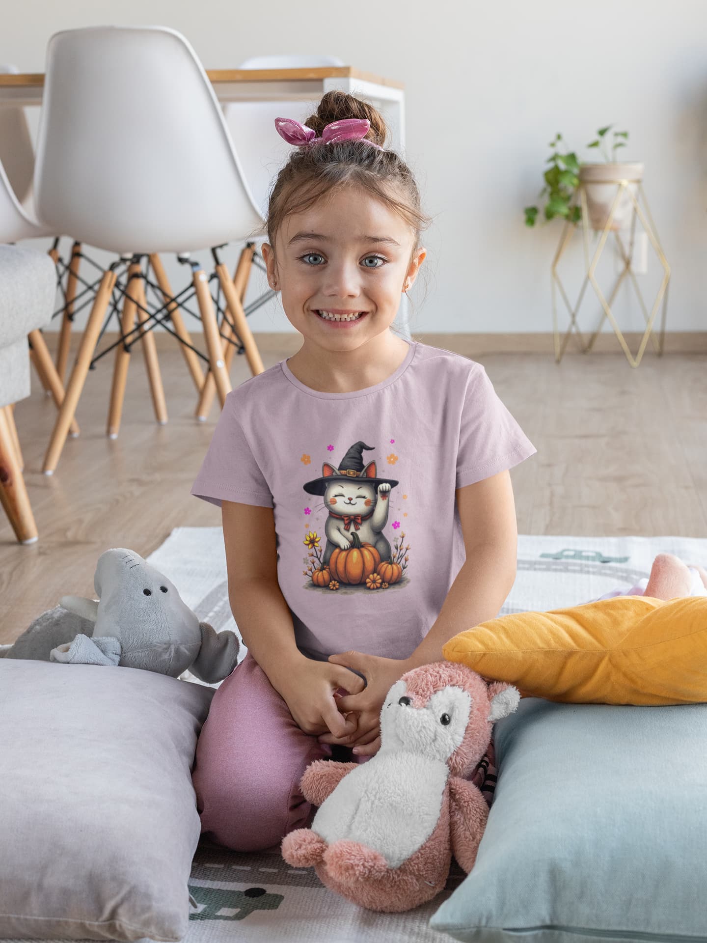 Model wearing Witch Luck Halloween cat t-shirt with lucky Maneki-neko cat in witch hat surrounded by colorful flowers, feminine and mystical design