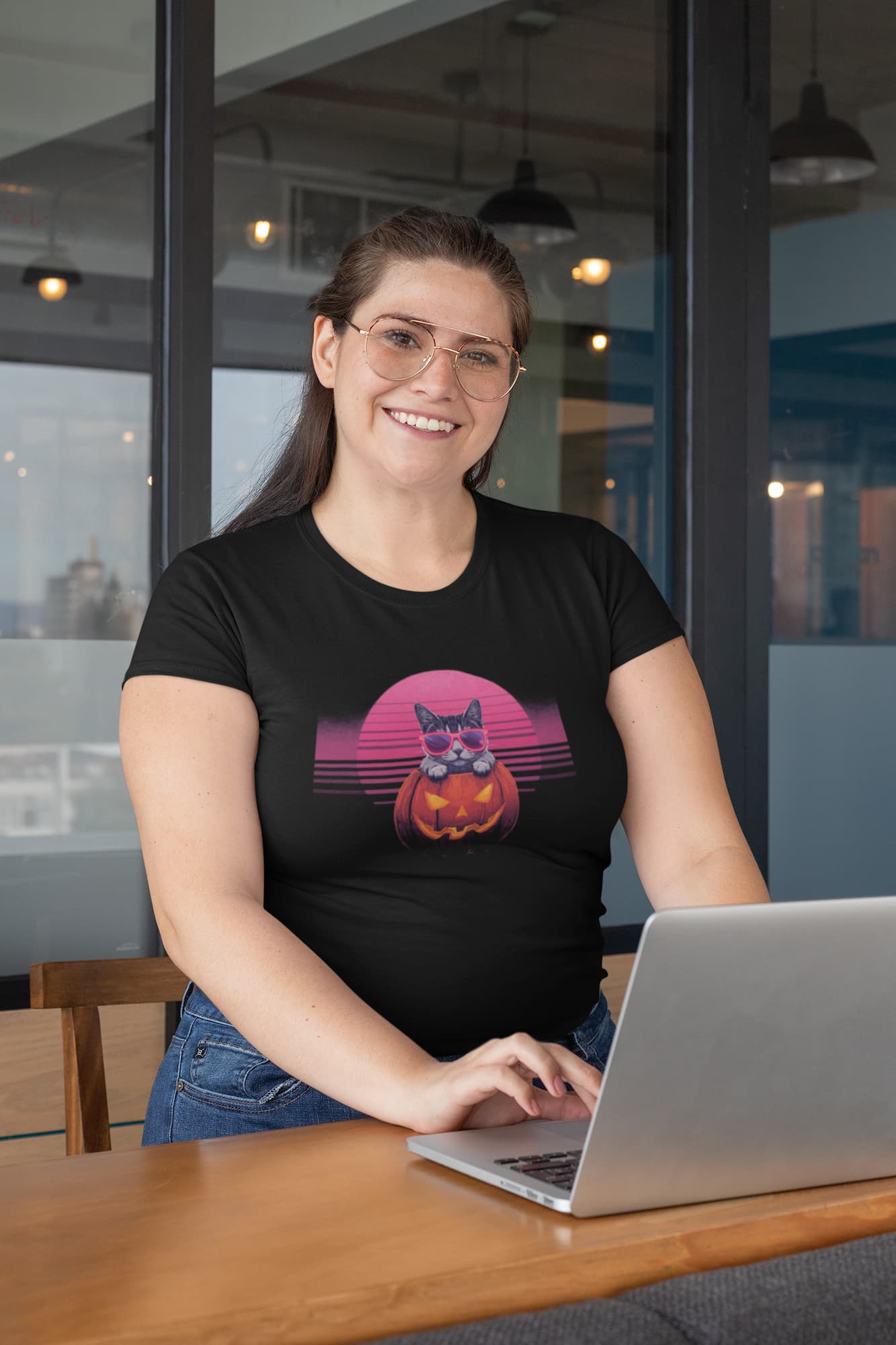 Person styling Neon Pumpkin Cat T-Shirt – bold Halloween design with jack-o’-lantern cat, neon vibes, and 80s retro flair.