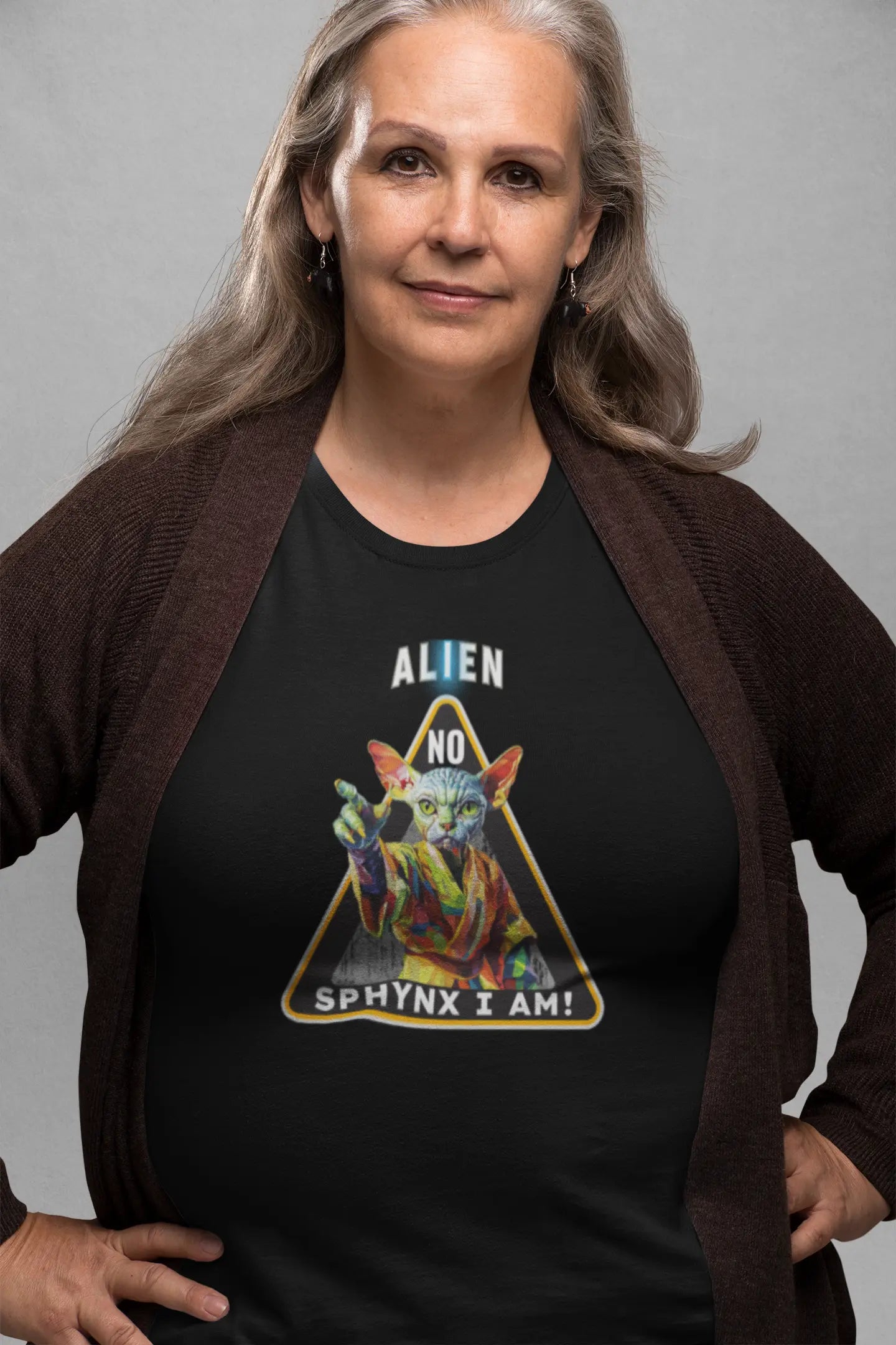 Model wearing the 'I Am Sphynx, Not Alien - The Galactic Hairless’ T-shirt with a sci-fi inspired Sphynx cat design, radiating humor, mystery, and nerdy feline attitude.