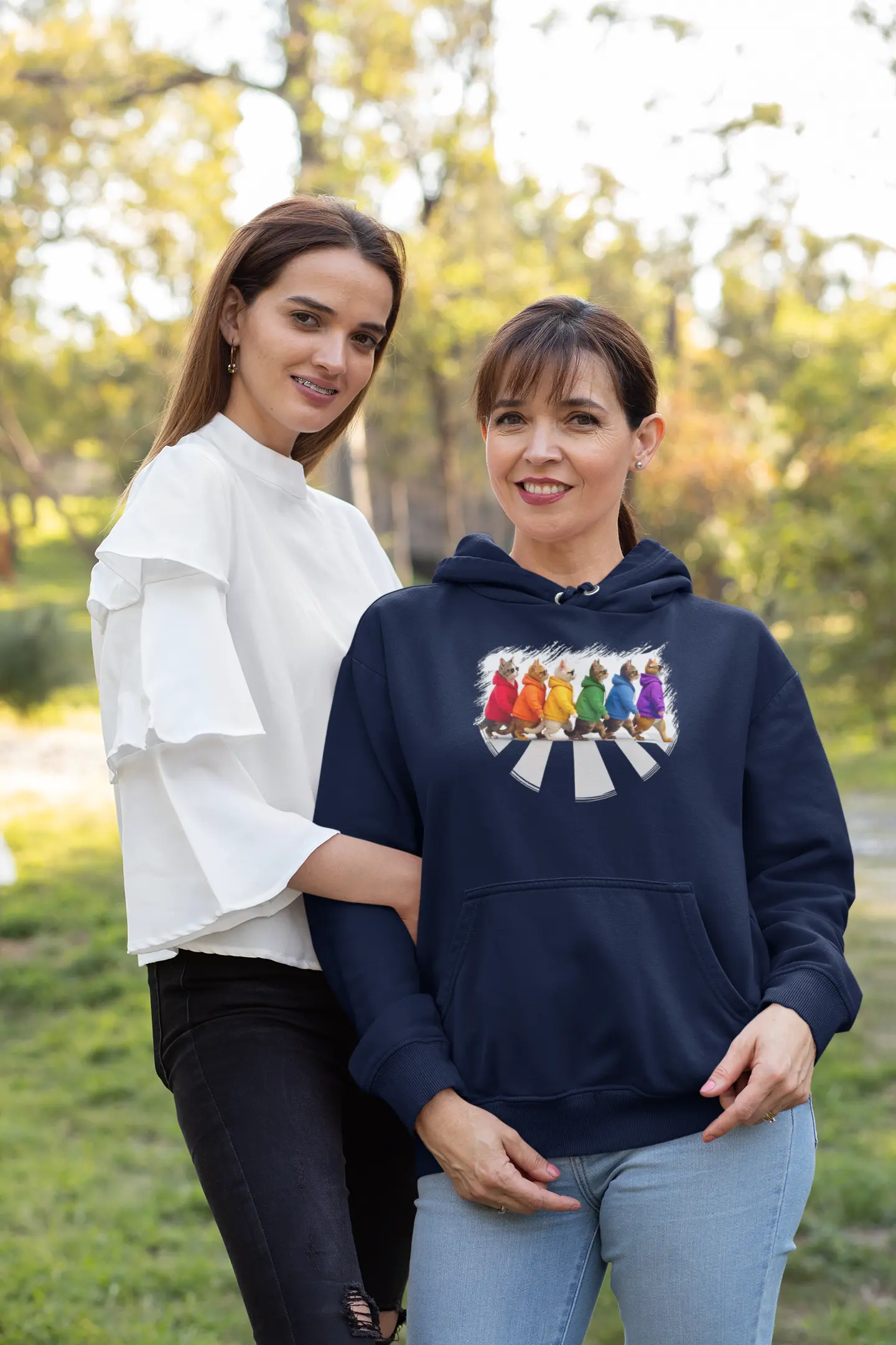 Person wearing Here Come the Cats unisex Hoodie in urban setting – stylish and playful cat lover tee celebrating music, pride, and individuality.