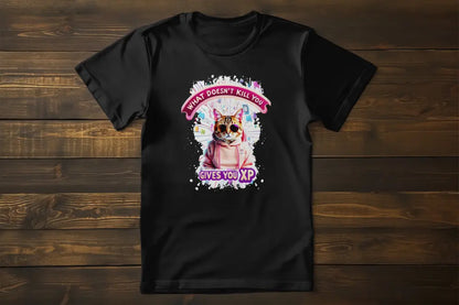 Flat lay of the 'Gamer Cat: What Doesn’t Kill You Gives You XP!' T-shirt displaying the illustrated gamer cat and XP-inspired typography.
