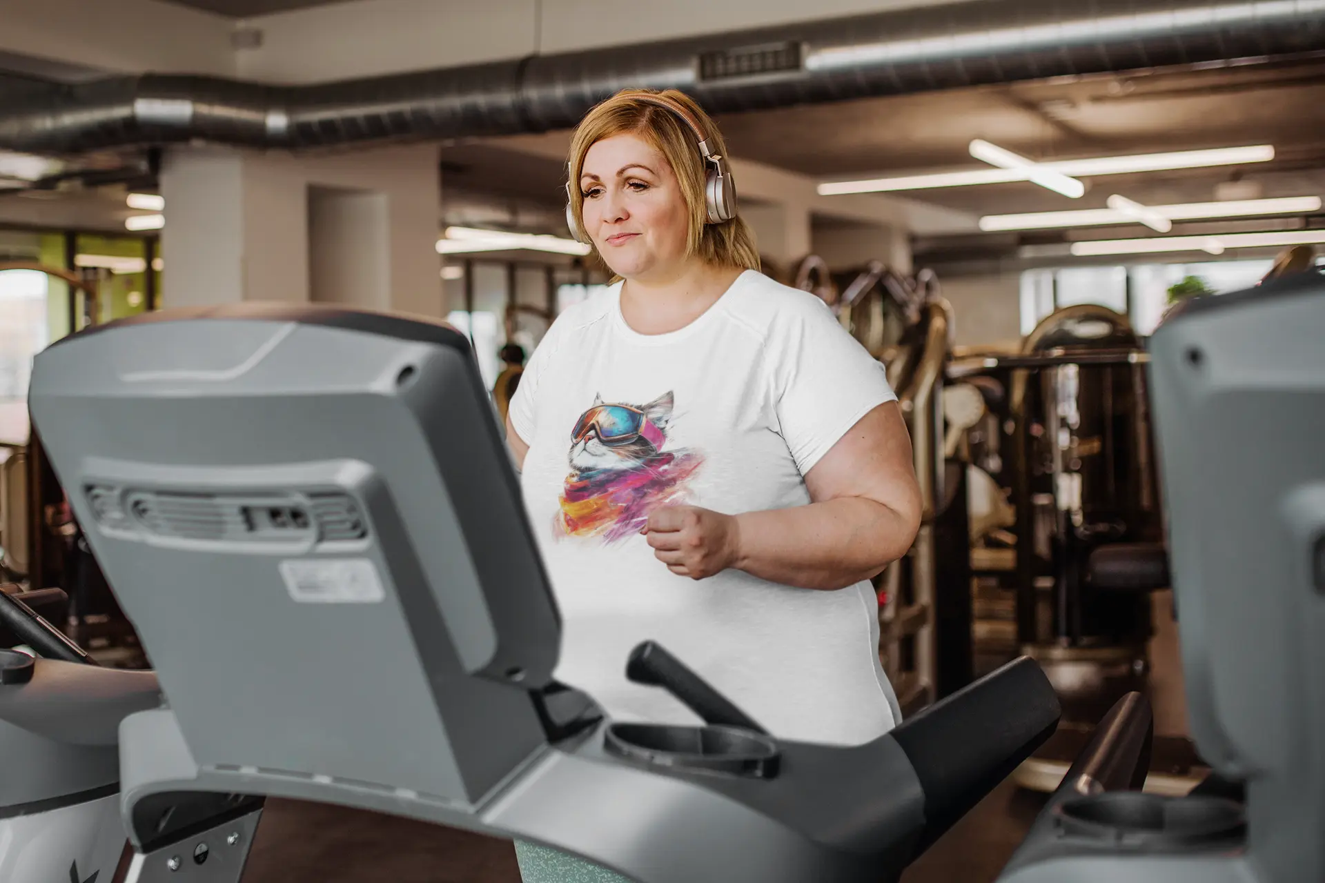 Model wearing Pink Snow Winter Cat T-Shirt – unisex premium tee featuring a chic cat with ski goggles and snowy mountain reflection.