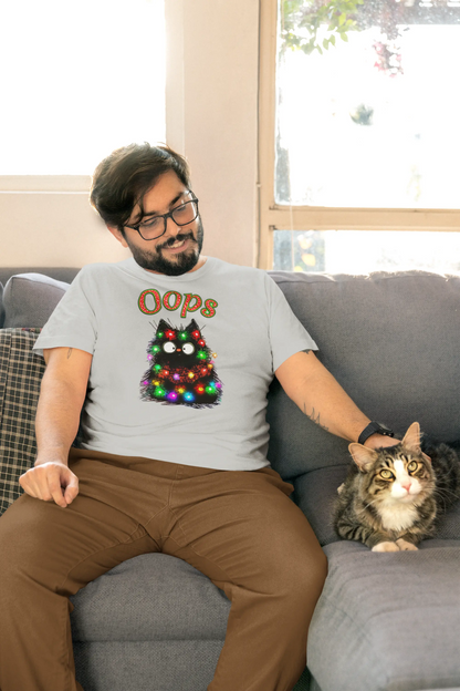 Person wearing Santa Claws Oops Cat T-Shirt while decorating Christmas tree – funny festive shirt for cat owners and holiday lovers.