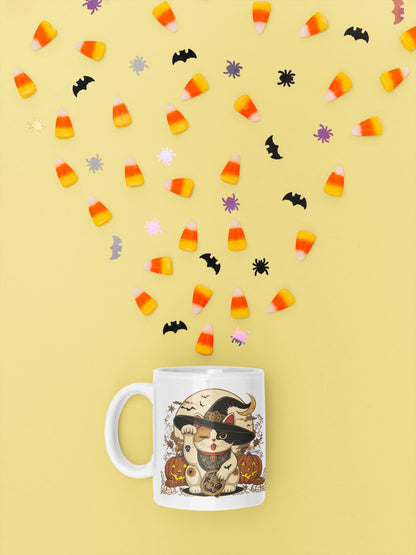 11oz ceramic mug Witchy Neko – Halloween Maneki-neko witch design with pumpkins, candles, and crescent moon, part of Felinamia’s Meowlloween collection.