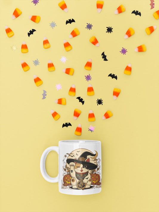 11oz ceramic mug Witchy Neko – Halloween Maneki-neko witch design with pumpkins, candles, and crescent moon, part of Felinamia’s Meowlloween collection.