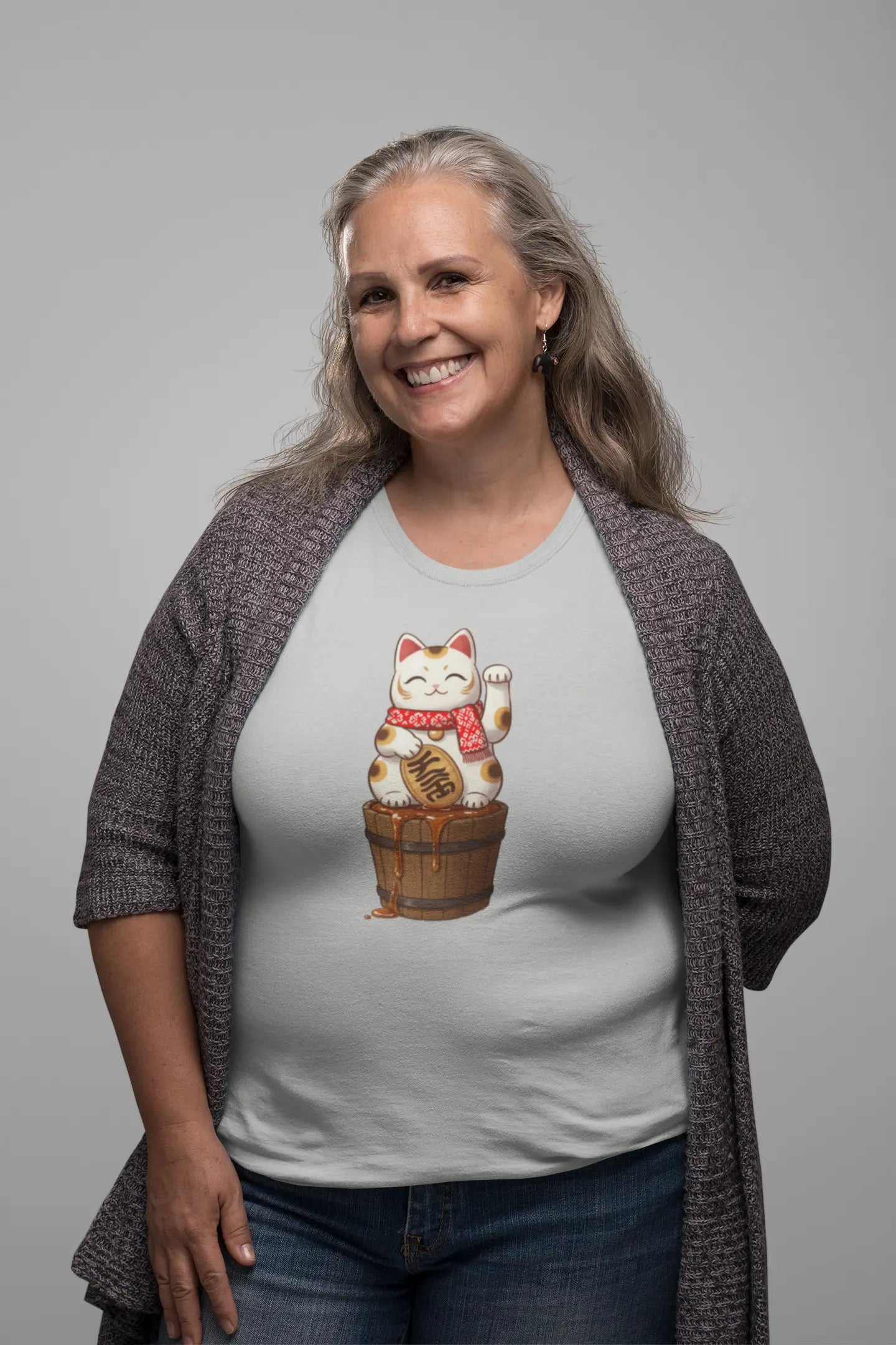 Person styling Lucky Maple Cat T-Shirt – playful Japanese lucky cat with scarf and maple syrup barrel, Canadian culture inspired.