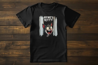Flat lay of the 'Here’s Kitty' T-shirt showing the cat peering through the door with bold text reading 'Here’s Kitty!' in a horror parody style.