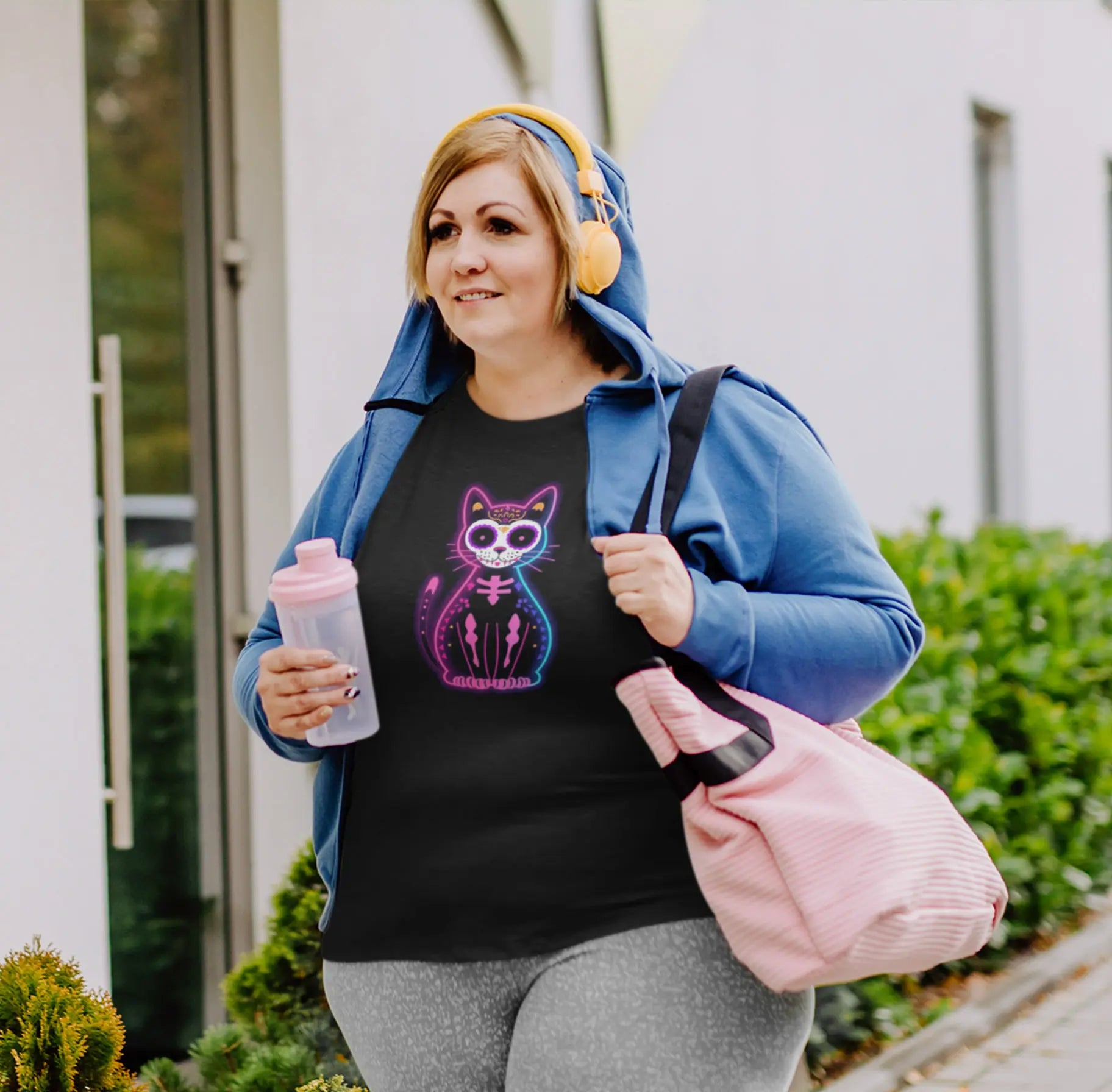 Woman styling Muertos Neon T-Shirt – colorful Día de los Muertos cat design with retro neon aesthetic.