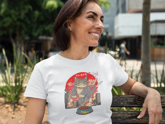 Model wearing The Hungry One Cat T-Shirt – unisex premium tee featuring a giant cat rampaging toward its food bowl in a humorous Japanese-style parody design.