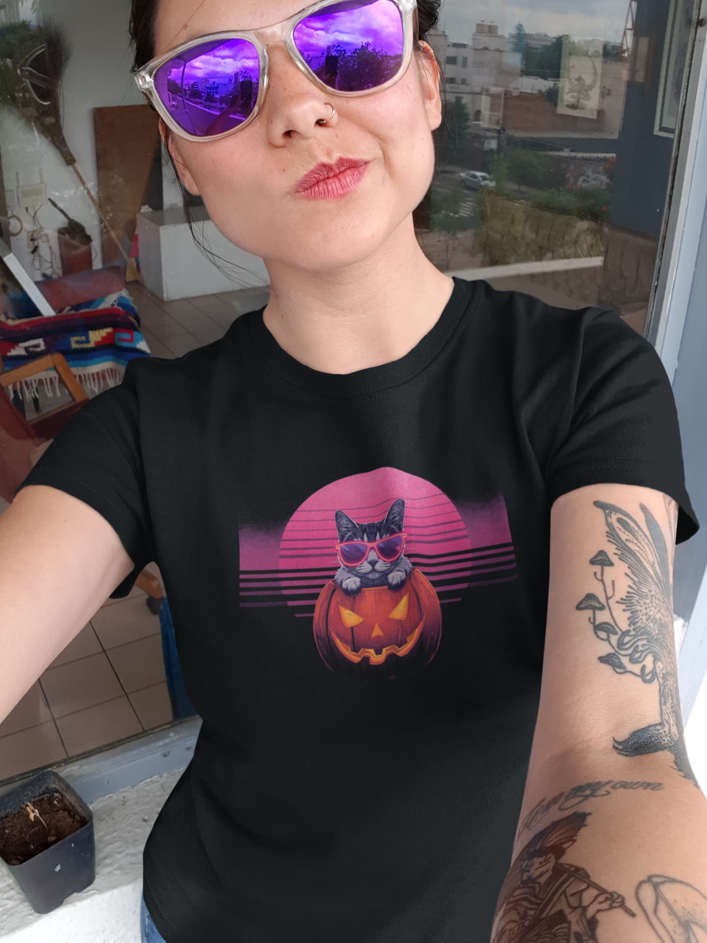 Person styling Neon Pumpkin Cat T-Shirt – bold Halloween design with jack-o’-lantern cat, neon vibes, and 80s retro flair.