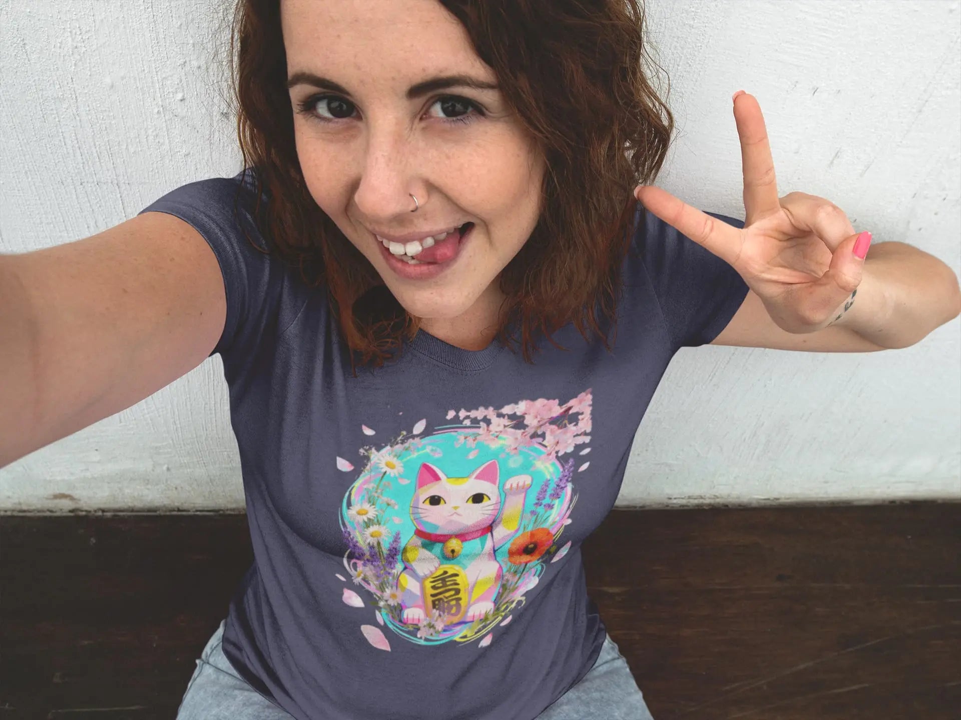 Model wearing a white Springwave Maneki cat t-shirt with an anime-style lucky cat illustration surrounded by bright colorful flowers, creating a cheerful and kawaii spring look.